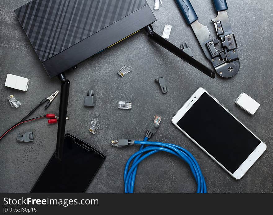 Smartphones and router with the necessary parts and tools to connect, on gray