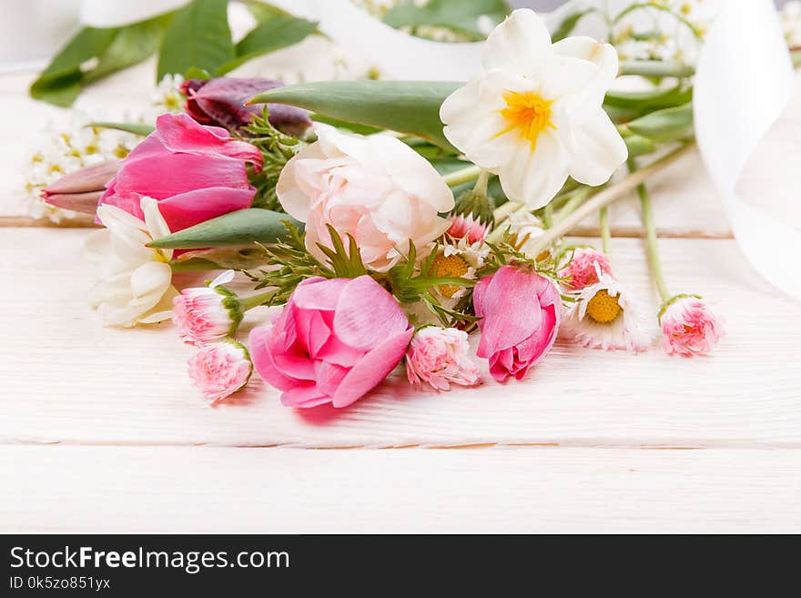 Festive flower pink, white anemones, tulips, daffodils, daisies composition on white wooden desk, background. Overhead top view, flat lay. Copy space. Birthday, Mother`s, Women`s, Wedding Day concept. Festive flower pink, white anemones, tulips, daffodils, daisies composition on white wooden desk, background. Overhead top view, flat lay. Copy space. Birthday, Mother`s, Women`s, Wedding Day concept