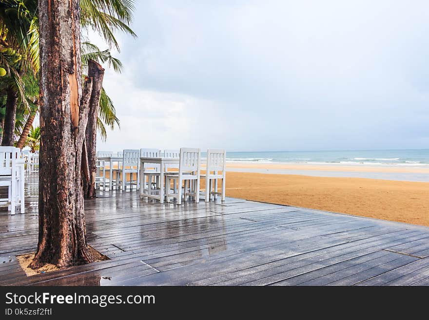 Wood floor and seaside table with beach and sea background after raining