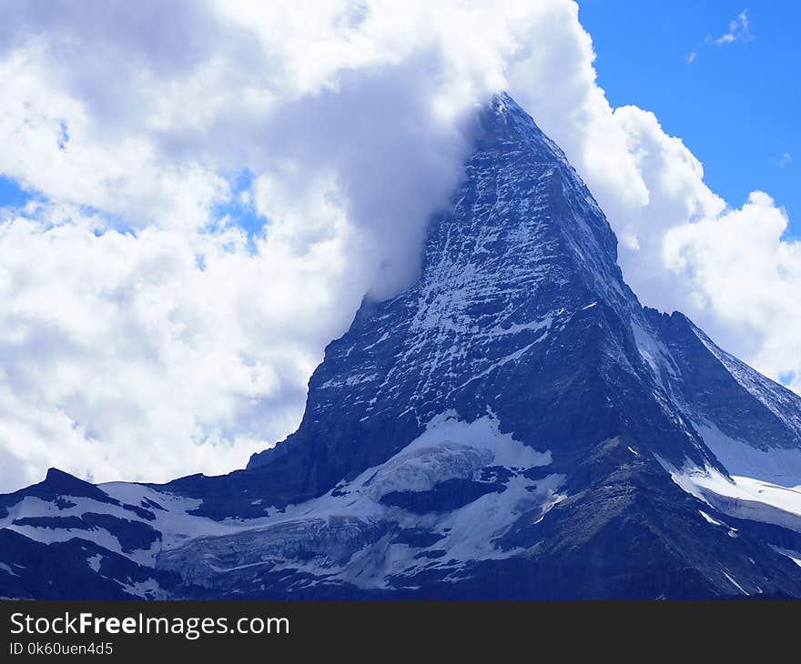 Scenic view of Matterhorn mount in clouds and alpine mountains range landscapes in swiss Alps seen from Gornergrat in SWITZERLAND with cloudy blue sky in 2017 warm sunny summer day, Europe on July. Scenic view of Matterhorn mount in clouds and alpine mountains range landscapes in swiss Alps seen from Gornergrat in SWITZERLAND with cloudy blue sky in 2017 warm sunny summer day, Europe on July.