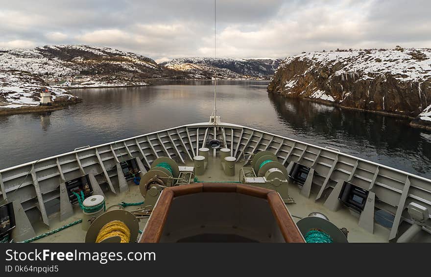 A cruise ship carefully sails through a strait located in northern Norway. A cruise ship carefully sails through a strait located in northern Norway