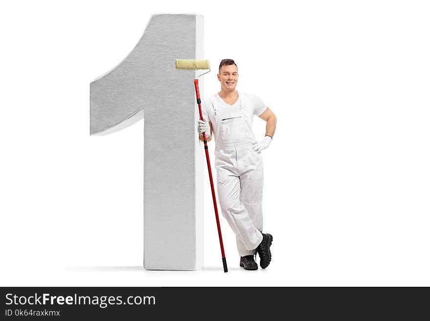 Full length portrait of a painter holding a paint roller and leaning against a number one figure isolated on white background