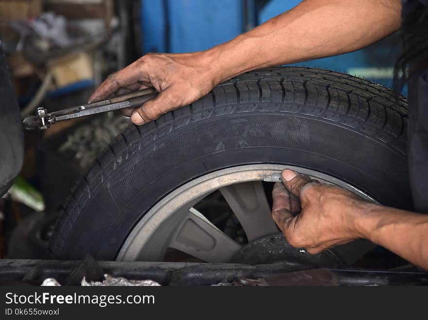 Worker use small lead for wheel Balancing at car service. Worker use small lead for wheel Balancing at car service.
