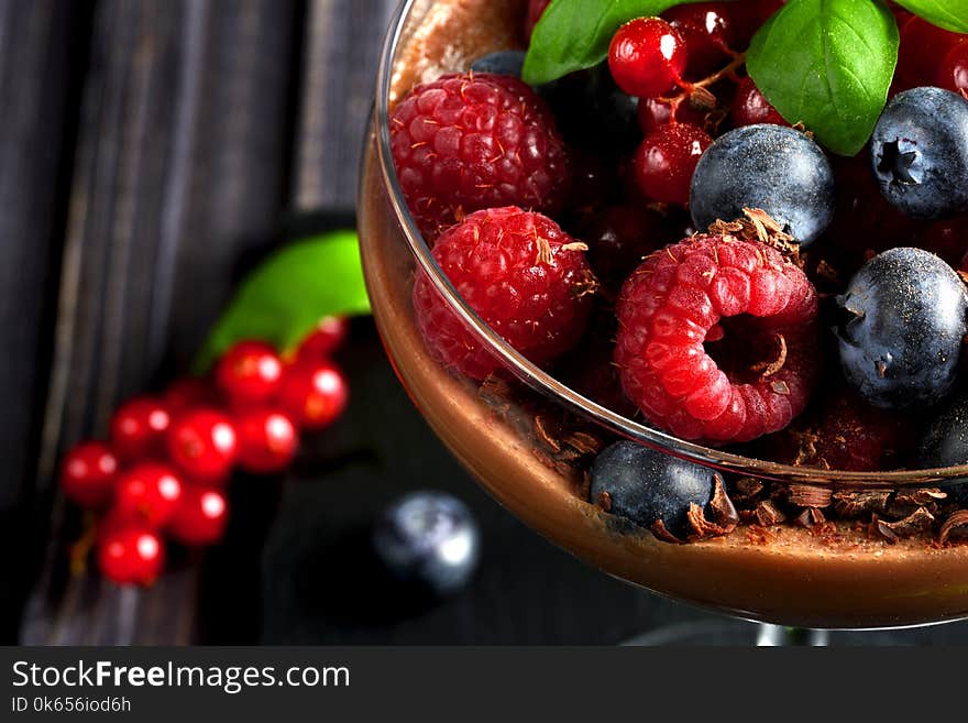 Ideas for a healthy diet. Dietary Chocolate mousse, parfait with fresh berries of raspberries, blueberries and red currants in a glass goblet