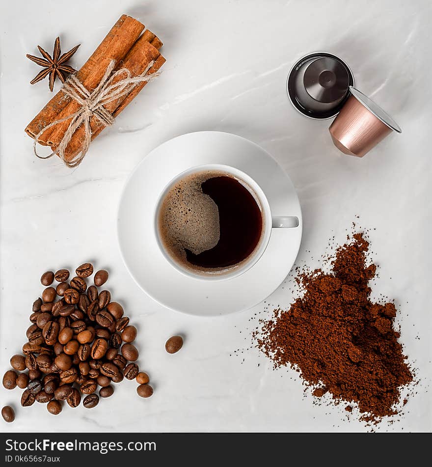 Espresso cup, coffee beans, coffee ground, coffee capsule and cinnamon with anise on a white background