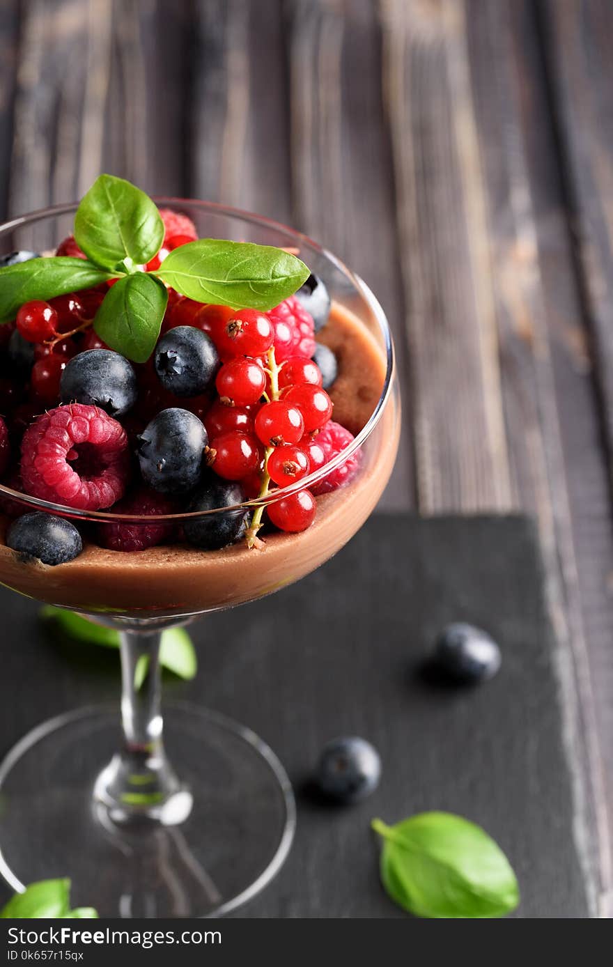 Ideas for a healthy diet: Dietary Chocolate mousse, parfait with fresh berries of raspberries, blueberries and red currants in a glass goblet