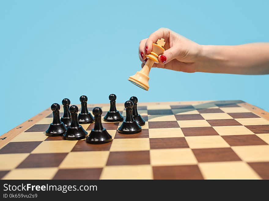 Ladies First. Chess board and game concept. Business ideas, competition, strategy and new ideas concept. Chess figures on blue background. Selective focus. Side view. Win, victory, winner concepts. Ladies First. Chess board and game concept. Business ideas, competition, strategy and new ideas concept. Chess figures on blue background. Selective focus. Side view. Win, victory, winner concepts