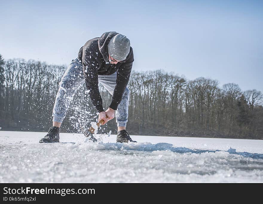 Person Holding Shovel on Snow Field