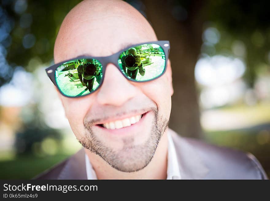 Shallow Focus Photography of Man in Gray Top Wearing Green Sunglasses With Black Frames