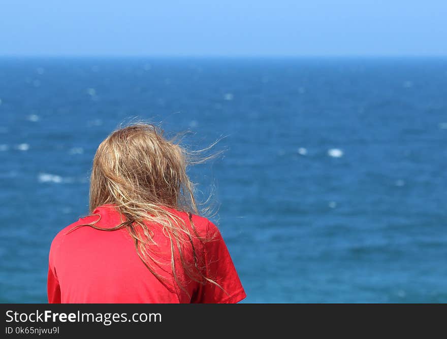 Person Wearing T-shirt Sitting Beside Seashore