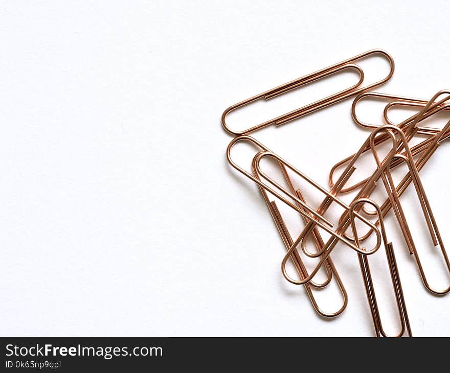 Brass-colored Paper Clips on White Surface