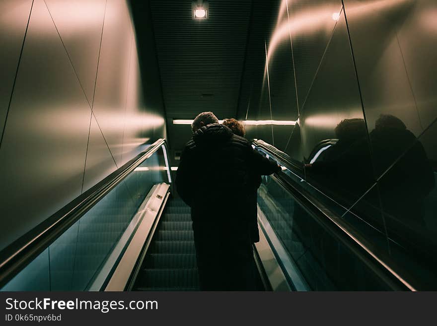 Person in Black Jacket Standing on Escalator