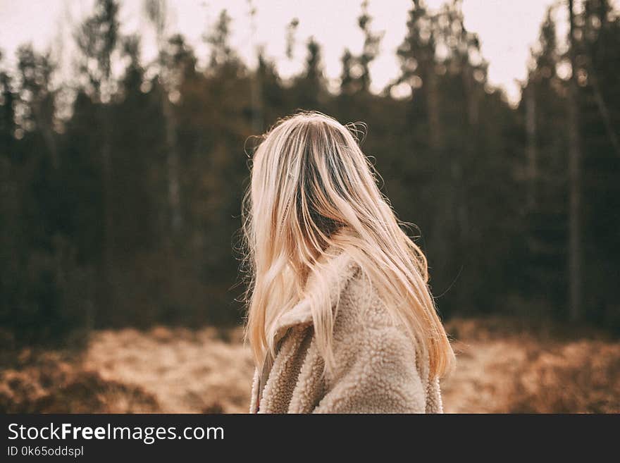 Depth of Field Photography of Woman Wearing White Coat Near Trees