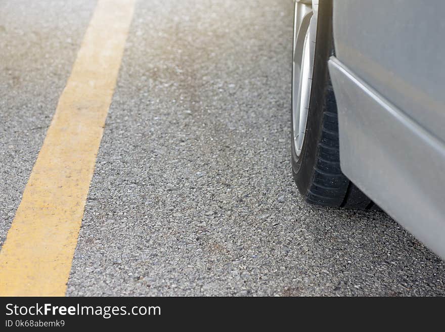 Car stop in parking lot with yellow Road Marking on the road.