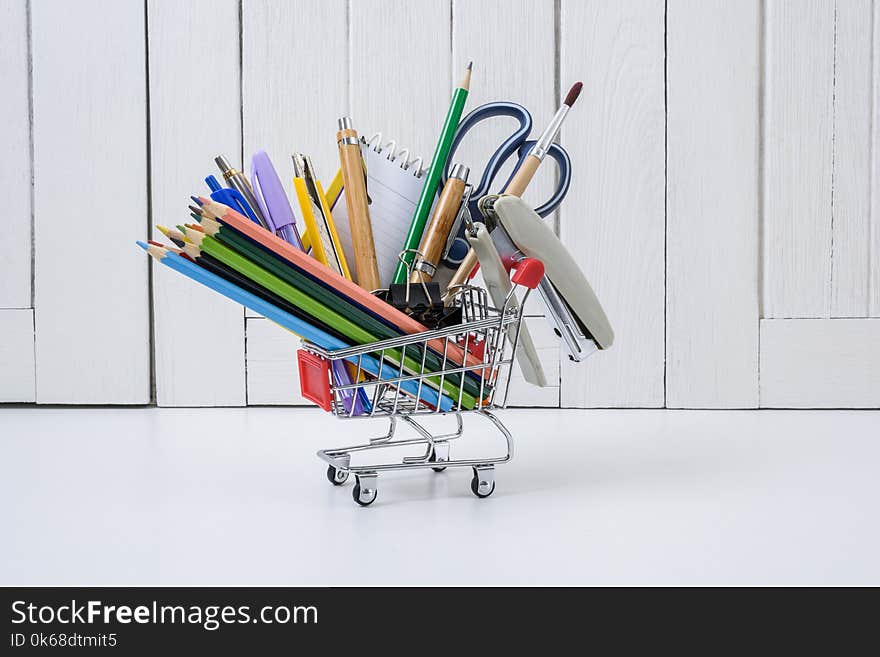 Education, Back to School, Shopping with shopping cart on table with White wooden vintage wall