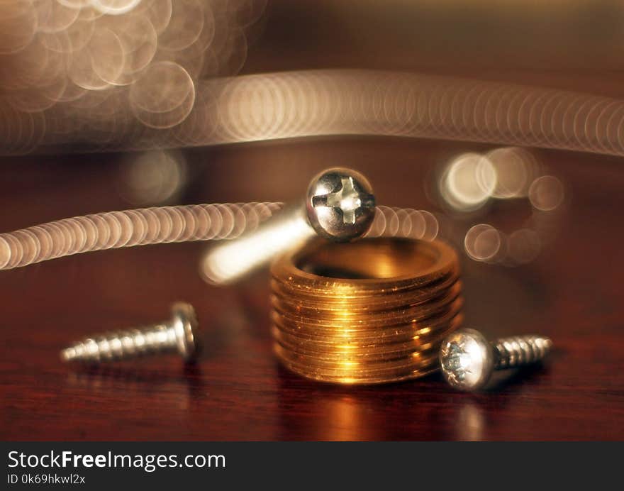 Metal Bolts, Screws, Lying On Table And A Bronze Part