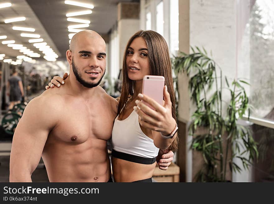 Beautiful athletic couple making selfie in gym after training. Beautiful athletic couple making selfie in gym after training