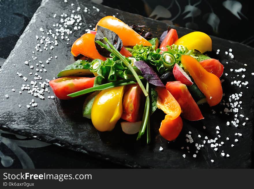 Sliced vegetables on a wooden board in a restaurant, cucumbers