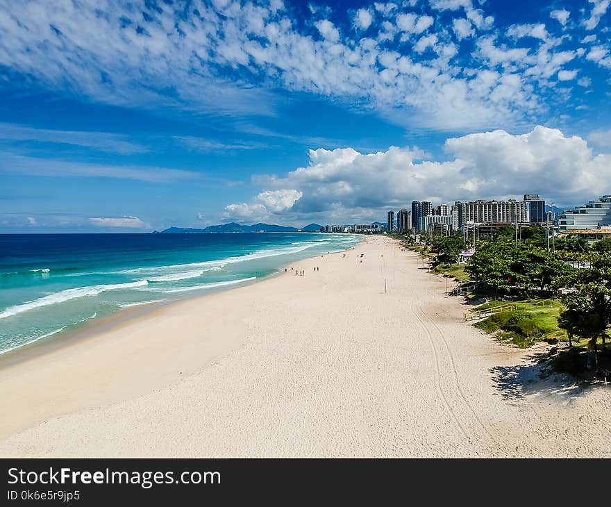 Drone photo of Barra da Tijuca beach, Rio de Janeiro, Brazil. We can see the beach, some building, the boardwalk, the road and the horizon