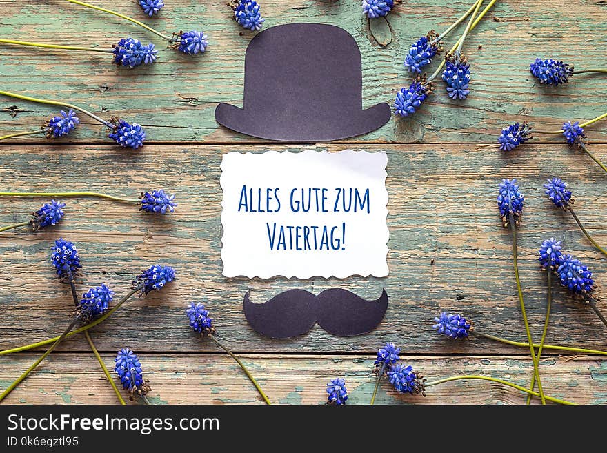 Father`s Day card with cardboard hat and mustache and blue flowe