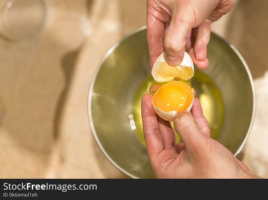 A woman holding an open chicken egg in her hands