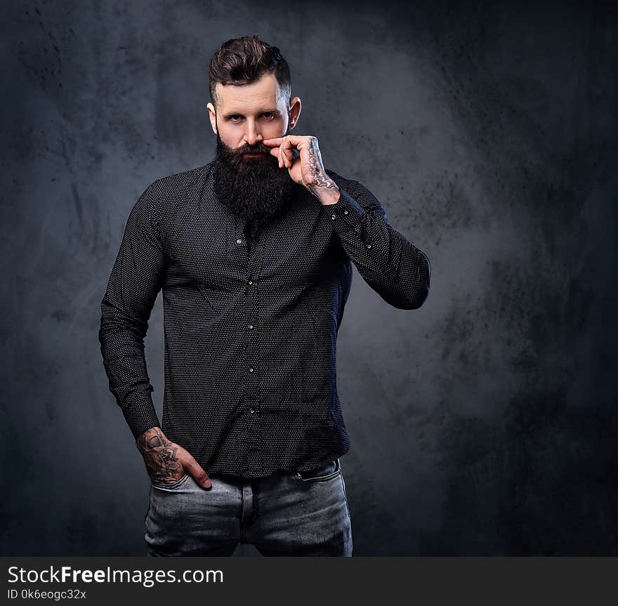 Stylish bearded male in a black shirt with tattoos on his arms. Stylish bearded male in a black shirt with tattoos on his arms.