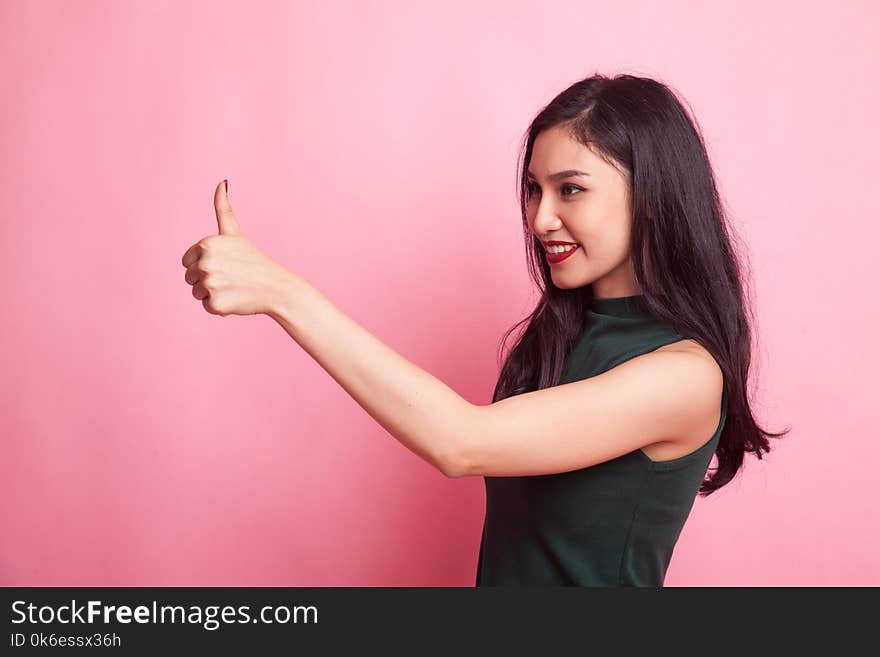 Asian woman thumbs up and smile on pink background. Asian woman thumbs up and smile on pink background