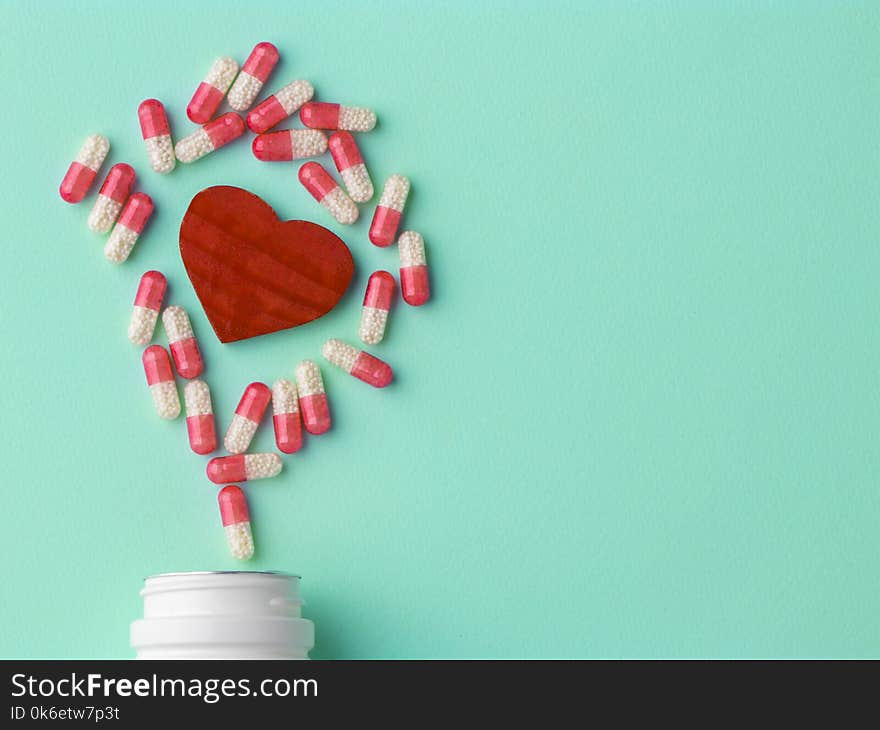 Meny different white and pink pills. Medicine background from much capsules. Drugstore set. Red heart