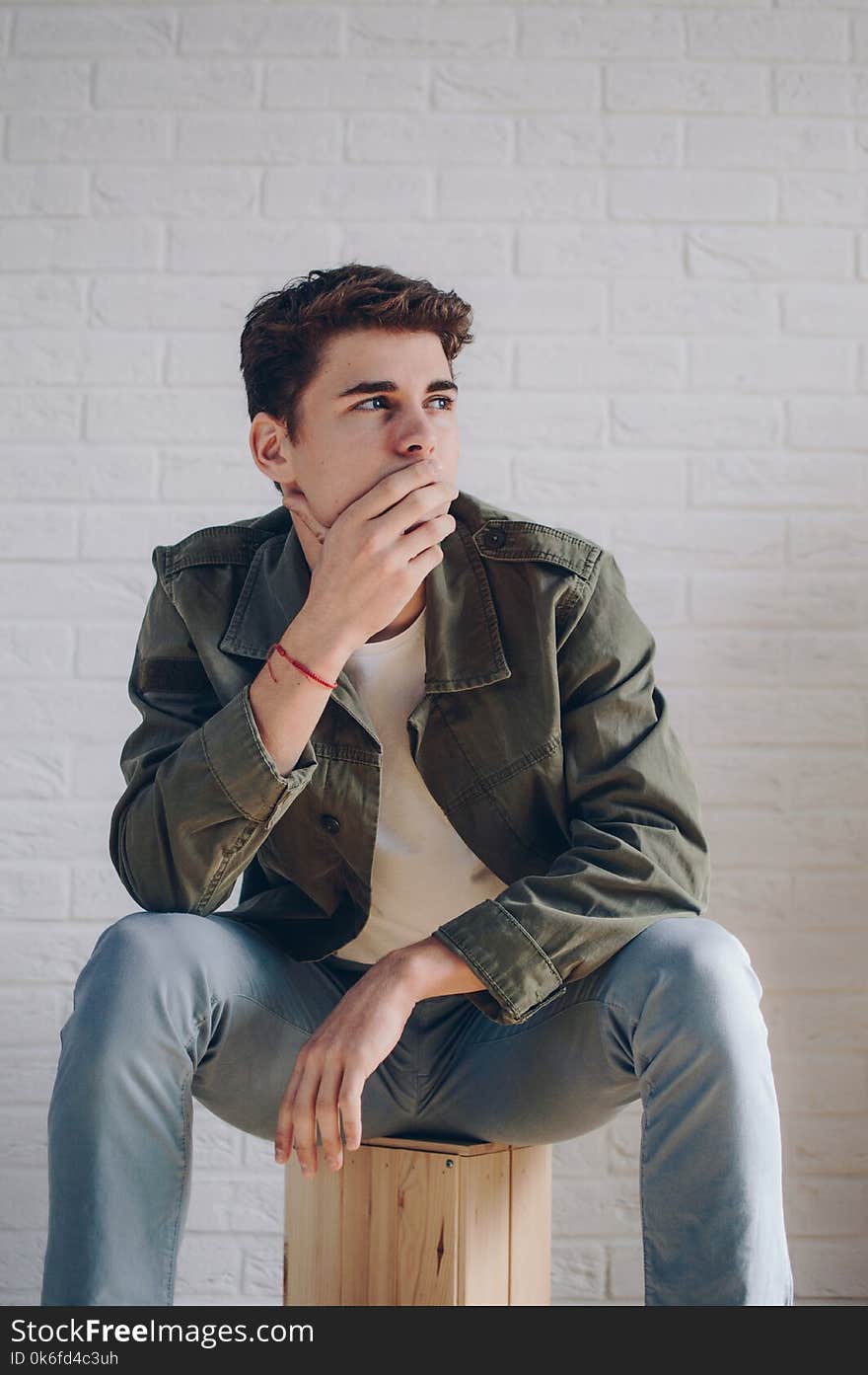 Man Wearing A Jacket Sitting On Brown Wooden Crate