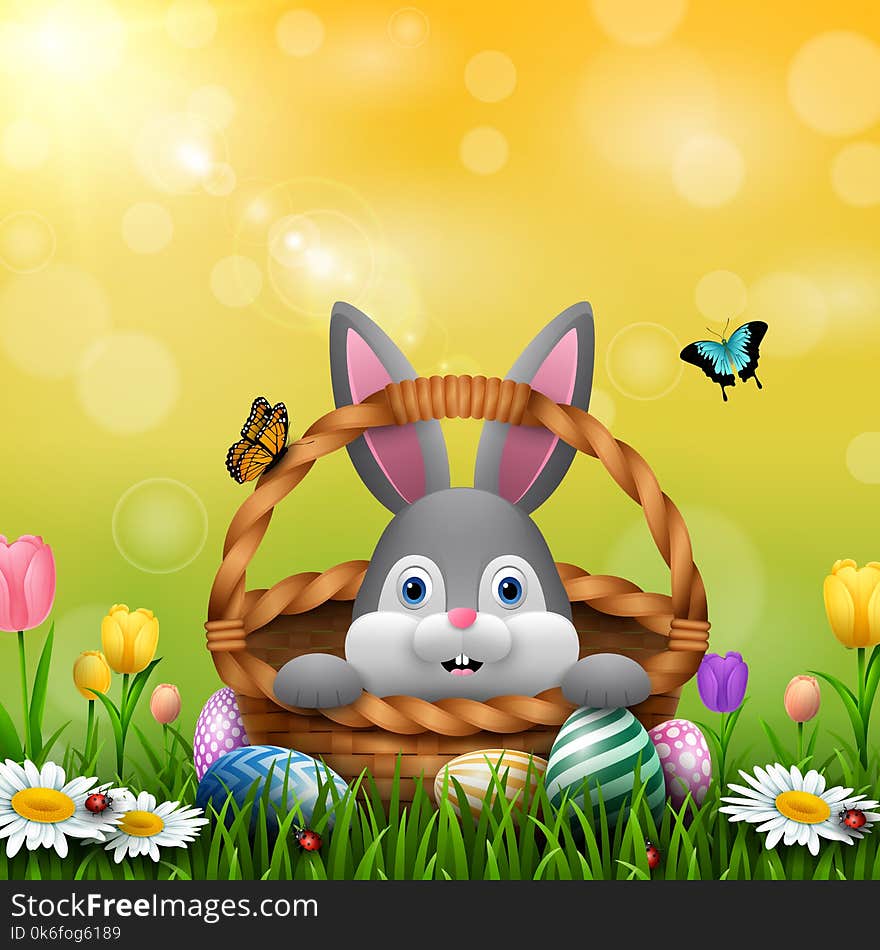 Illustration of Cute Easter bunny in a basket with colorful eggs on the grass