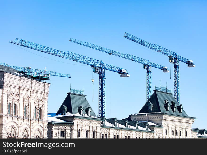 Tower crane on a construction site against a blue sky