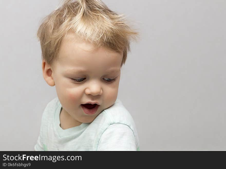 Cute two years toddler in sleepwear on the grey background.