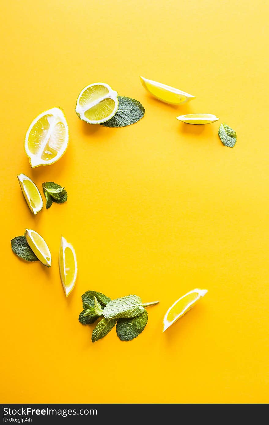 Bright mint leaves and lemon slices on yellow