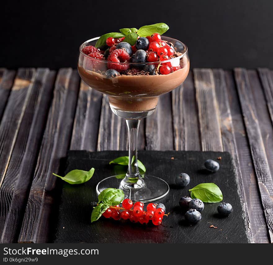 Ideas for a healthy diet. Dietary Chocolate mousse, parfait with fresh berries of raspberries, blueberries and red currants in a glass goblet