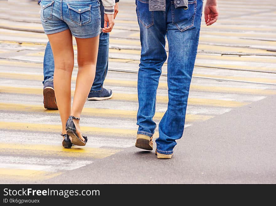 People crossing the pedestrian crossing on sunny summer day. People crossing the pedestrian crossing on sunny summer day