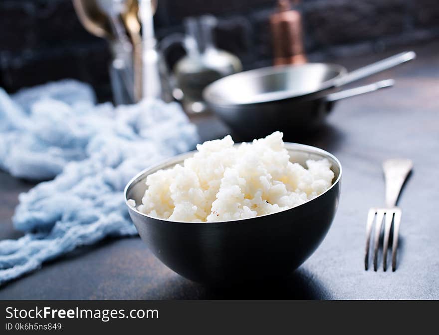 Boiled rice in bowl and on a table