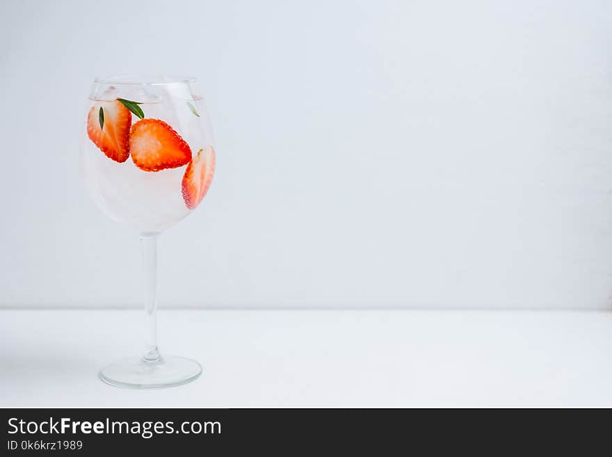 Gin with strawberry and ice in wine glass. Selective focus.