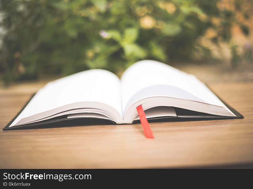 An open book on wooden table at home garden with nature bokeh b