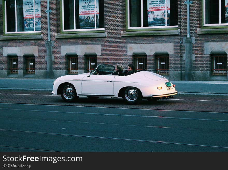 Two People Riding White Classic Convertible Car