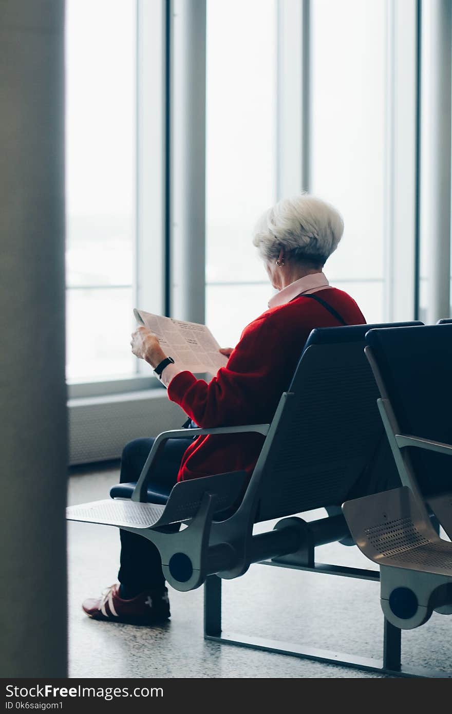 Person In Red Coat Sitting On Chair