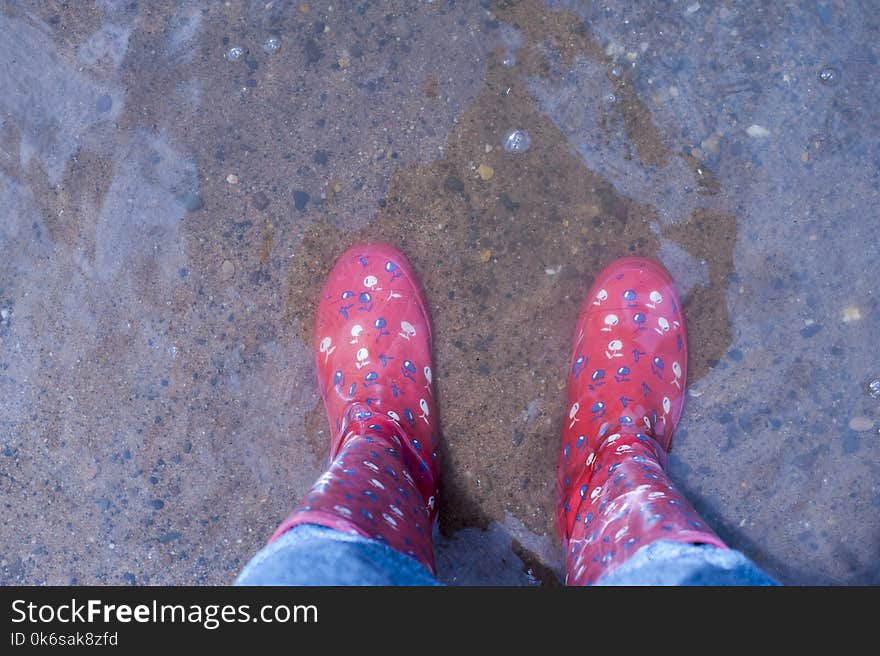 Person Wearing Pink Knee-high Rain Boots Standing on Brown Floor