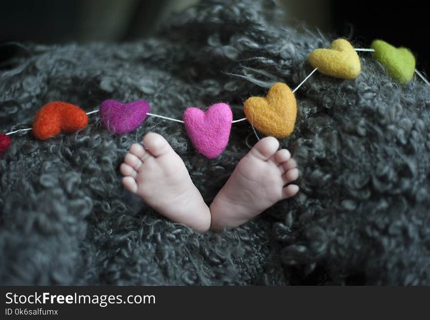 Baby&#x27;s Feet Covered With Black Wool Textile