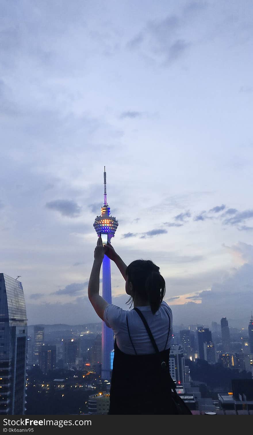 Woman in White and Black Shirt Standing Beside White Tower