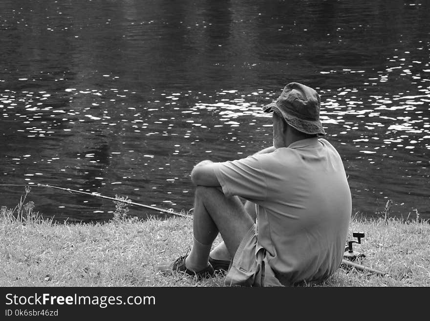 Man Sitting Facing Body Of Water