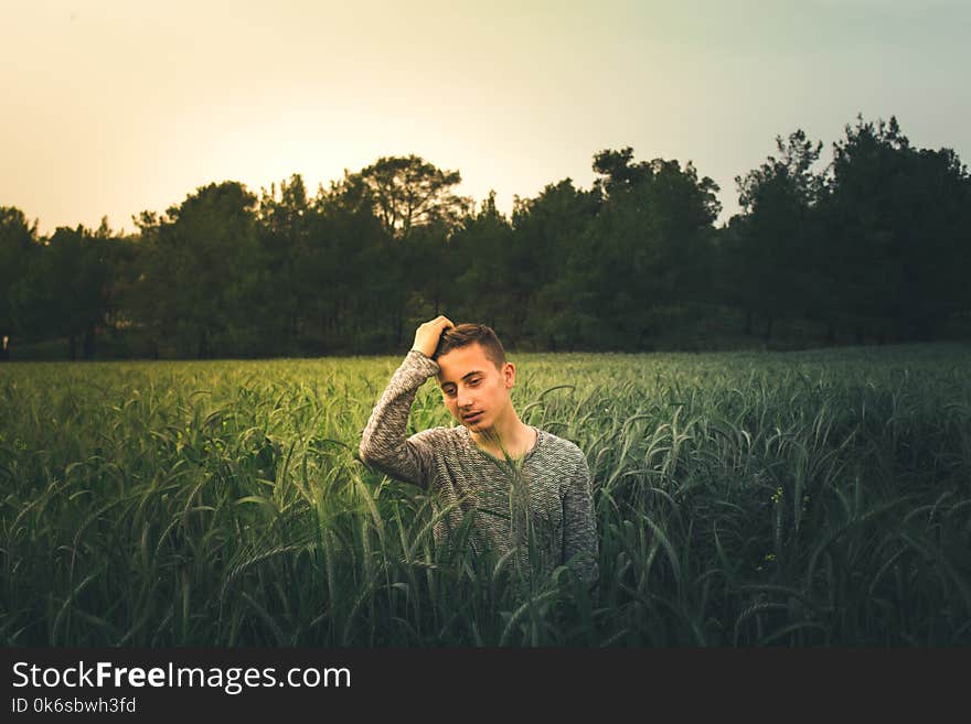 Man Wearing Gray Sweatshirt Standing On Grass Field