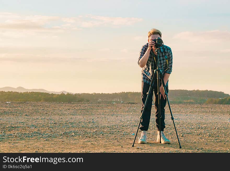 Man Wearing Sport Shirt While Holding Camera