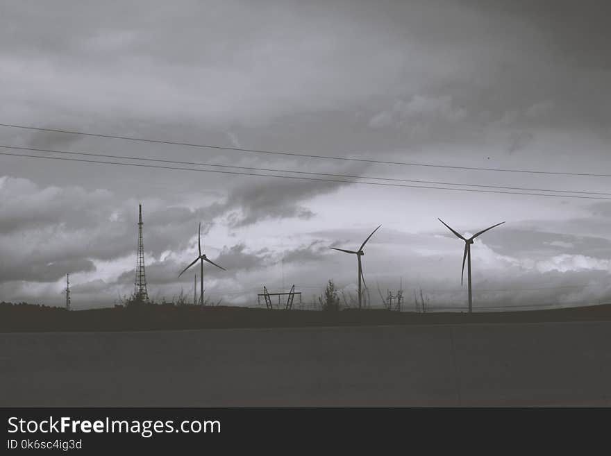 Three Wind Mills Under Cloudy Sky