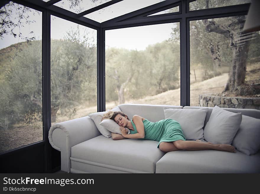 Woman Sleeping On Sofa With Throw Pillows