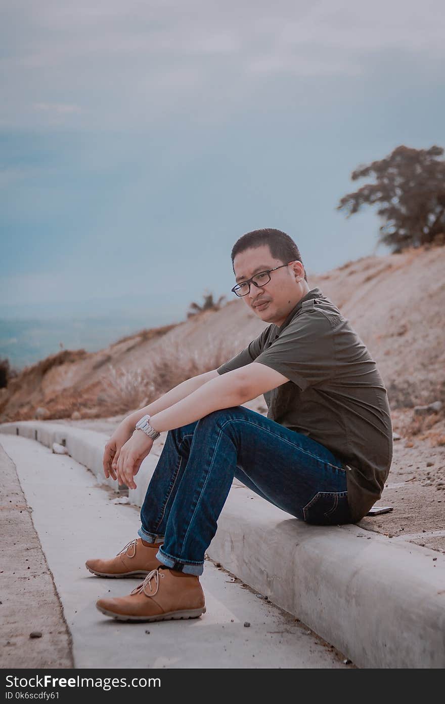 Man Sitting On Road Gutter