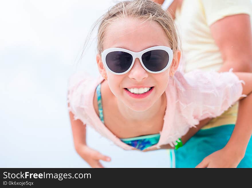 Little girl outdoors during summer vacation have fun with father. Portrait of a kid upside down on a sky background